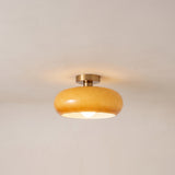 Amber glass flush mount ceiling light with copper stem, lit product photo