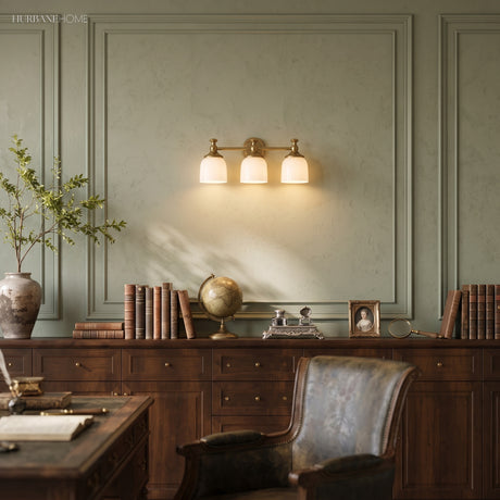 Three light milk glass vanity sconce above a desk in a green study