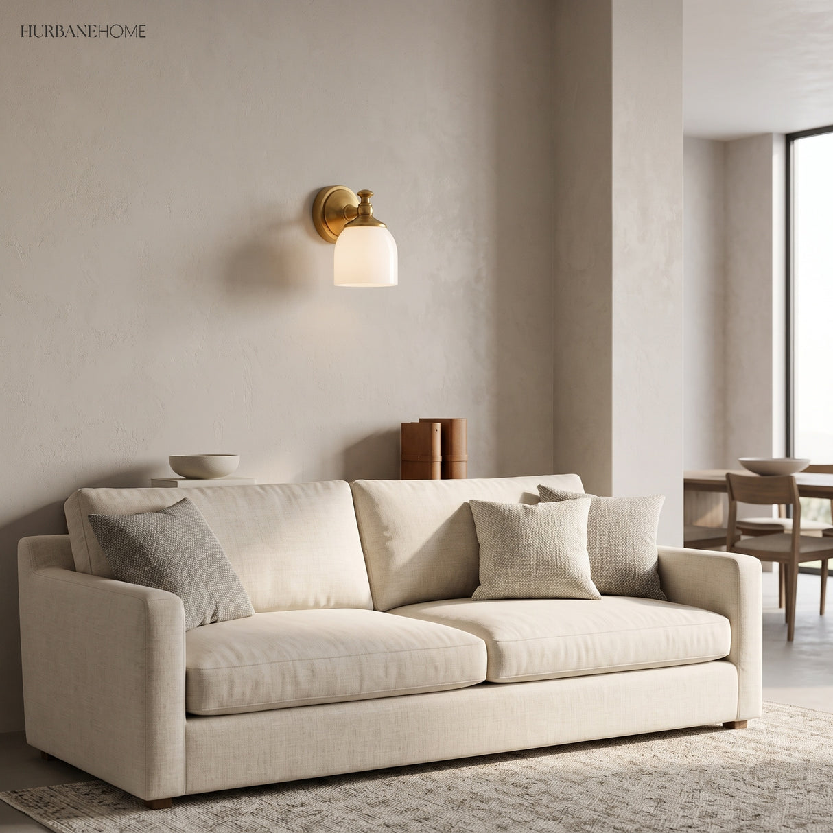 Single brass milk glass wall light above a pale sofa in a living room