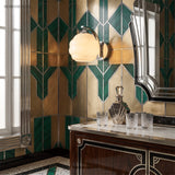 Chrome and opal glass sconce on green and gold geometric tiled wall