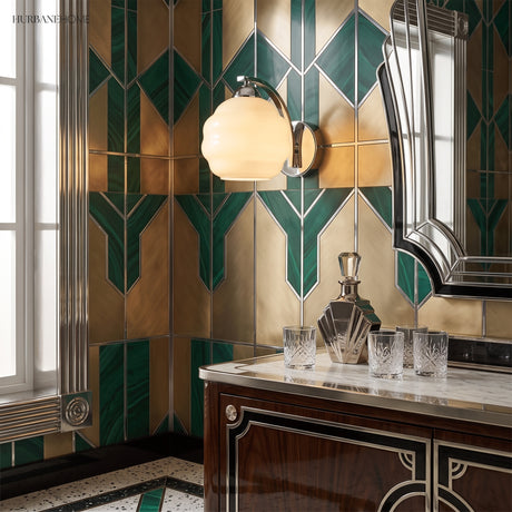 Chrome and opal glass sconce on green and gold geometric tiled wall