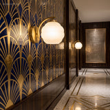 Two opal glass sconces along a gold fan patterned Art Deco corridor