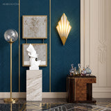 Gold fan sconce lit on a blue wall beside framed artwork