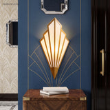 Gold fan sconce lit on a blue wall above a timber console