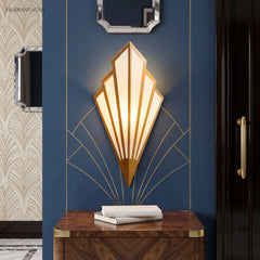 Gold fan sconce lit on a blue wall above a timber console