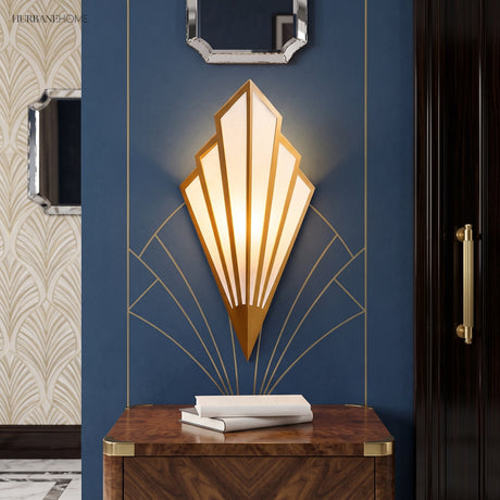 Gold fan sconce lit on a blue wall above a timber console