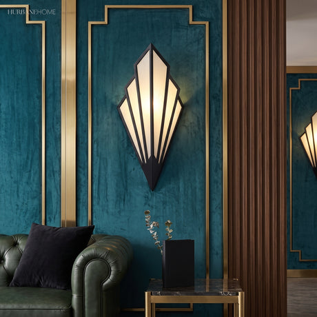 White fan sconce lit on a deep teal panelled wall above a sofa