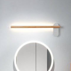 Slim wood vanity light lit above a round mirror on plain grey