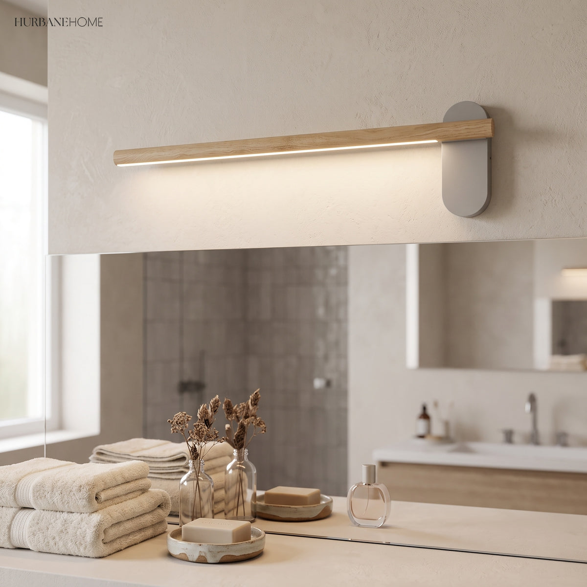 Slim wood vanity light lit above a stone bathroom vanity top