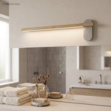 Slim wood vanity light lit above a stone bathroom vanity top