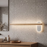 Slim wood vanity light lit on a terrazzo wall above a basin