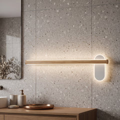 Slim wood vanity light lit on a terrazzo wall above a basin