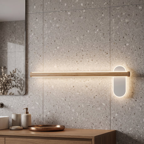 Slim wood vanity light lit on a terrazzo wall above a basin