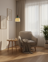Beaded pendant hung above a side table beside a grey armchair and curtains