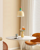 Beaded pendant above a small cafe table and chairs in front of window blinds