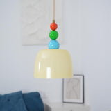 Close view of the lit beige shade and beads above a dark blue sofa