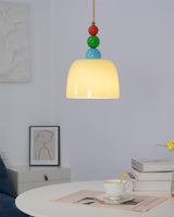 Beaded pendant above a small white round table with a cup and open book