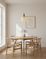 Beaded pendant above a round dining table with pale wishbone style chairs