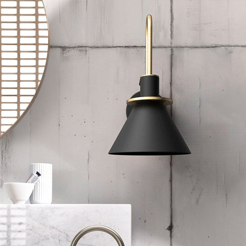 Black cone sconce beside a round mirror on a concrete bathroom wall