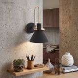 Black cone sconce on a concrete wall above a floating timber shelf