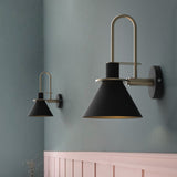 Two black cone sconces on a grey blue wall above pink panelling