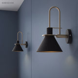 Two black cone sconces spaced along a slate blue bedroom wall
