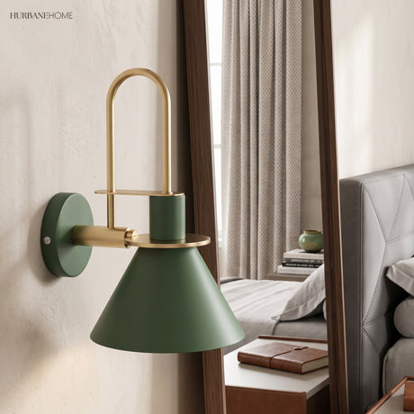 Green cone wall sconce beside a bedroom mirror and made bed