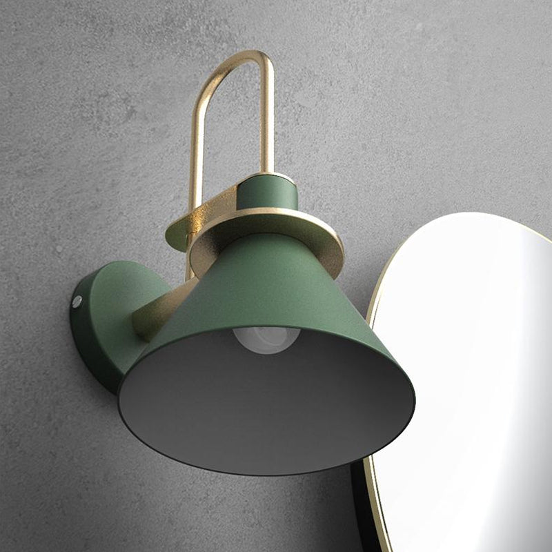 Green cone sconce lit against grey concrete beside an oval mirror
