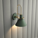 Green cone sconce lit warm against a fluted cream wall panel