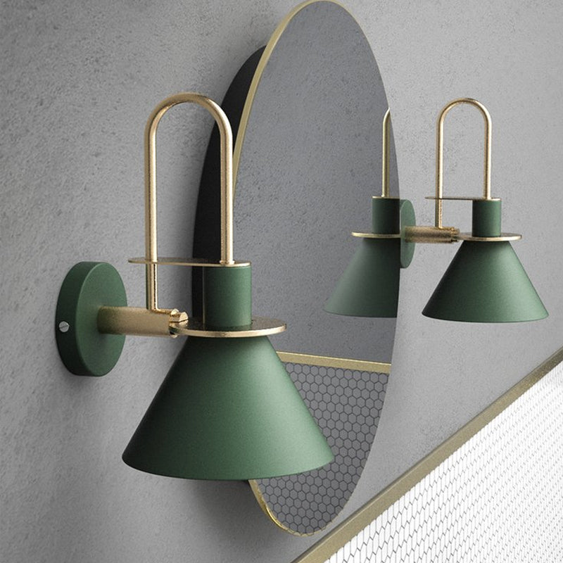 Two green cone sconces flanking a large round mirror on grey