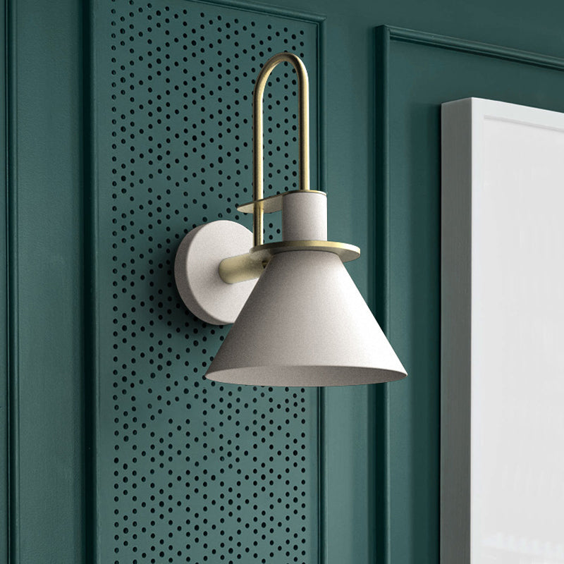 White cone sconce mounted on a green perforated panel by a frame