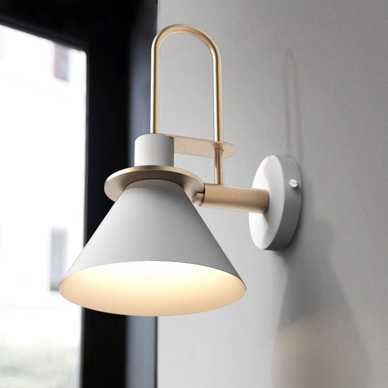 White cone sconce glowing warm on a pale grey bedroom wall
