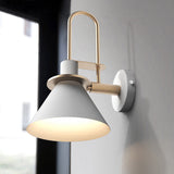 White cone sconce glowing warm on a pale grey bedroom wall