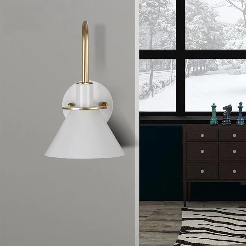White cone sconce beside a window view of a snowy garden