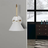 White cone sconce beside a window view of a snowy garden