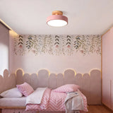 Round wood ceiling light mounted above a bed in a warm minimalist bedroom