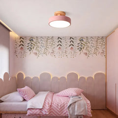 Round wood ceiling light mounted above a bed in a warm minimalist bedroom