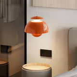 Bud shaped metal pendant light hanging beside a bed in a cosy bedroom
