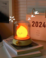 Night light on a stack of books beside a desk calendar and framed print