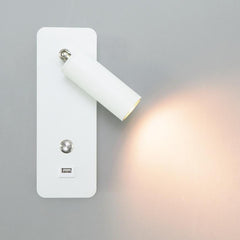 White bedside reading light with an angled head casting a warm pool