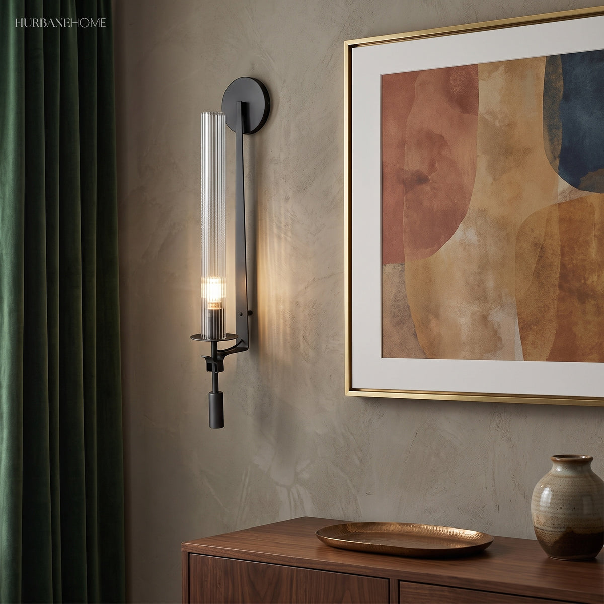 Black fluted glass sconce lit beside a framed abstract print