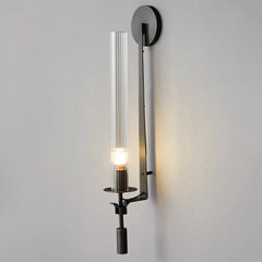 Black fluted glass sconce with an exposed candle bulb lit warm