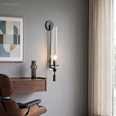 Black fluted glass sconce lit above a desk and leather chair