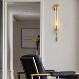 Gold fluted glass sconce lit in a hallway beside a doorway