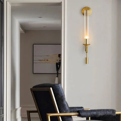 Gold fluted glass sconce lit in a hallway beside a doorway