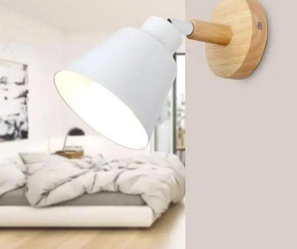 White bell shade sconce lit above a table with ceramic bowls