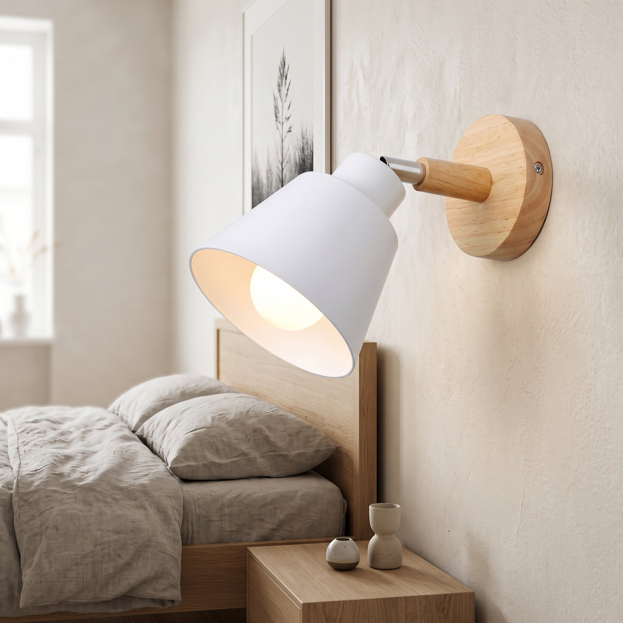 White bell shade wall sconce on a wood mount lit beside a bed