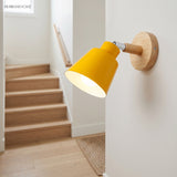 Yellow bell shade sconce lit on a wall beside a staircase