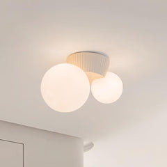 Close view of the beige fluted canopy above the two lit opal globes