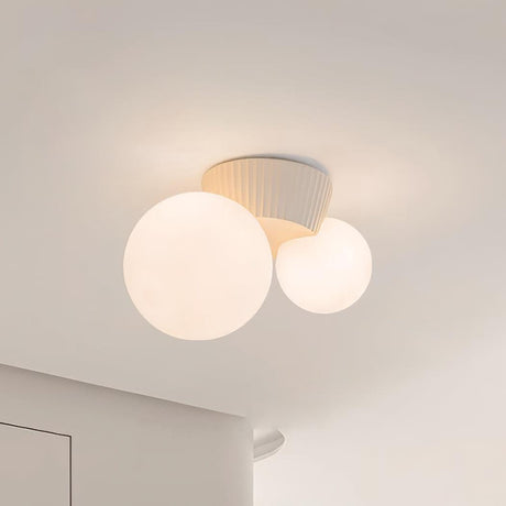 Close view of the beige fluted canopy above the two lit opal globes